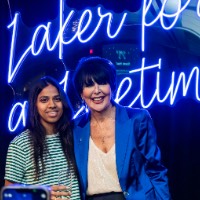 Girl stands on the left of President Mantella to take a photo with iPhone